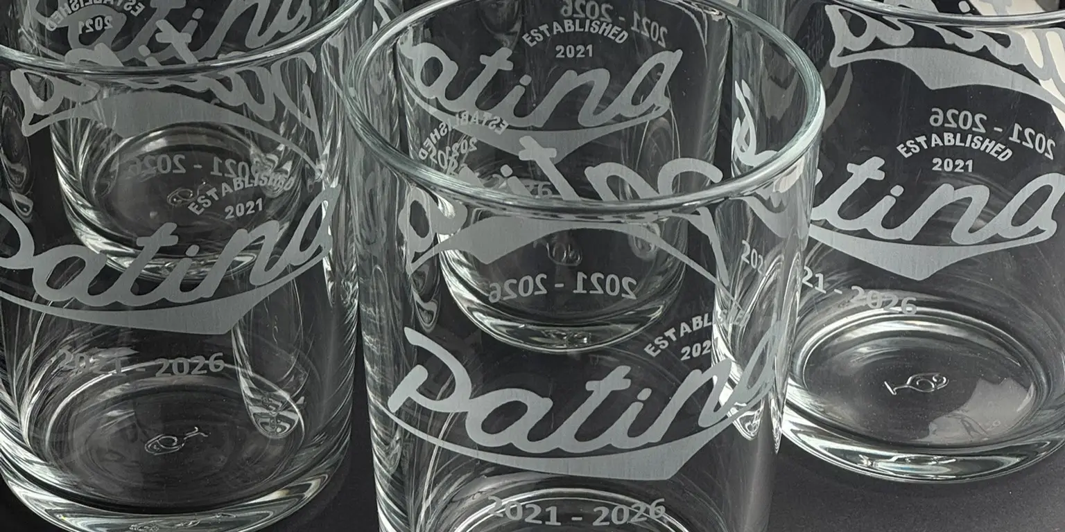 Bodega glasses engraved with a business’s script logo and anniversary dates