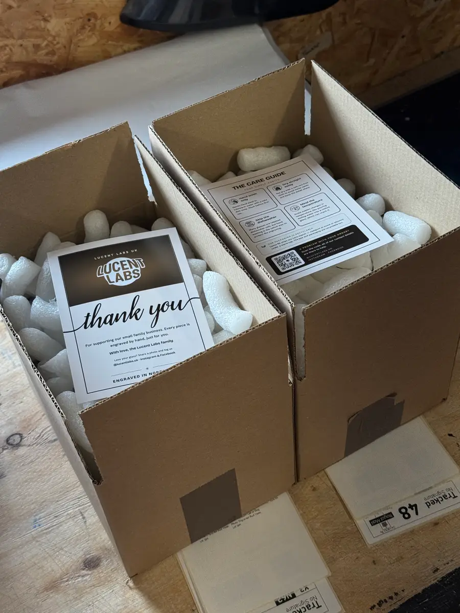 Two orders boxed with tissue, void fill, a care guide and a thank-you card, labelled for tracked delivery